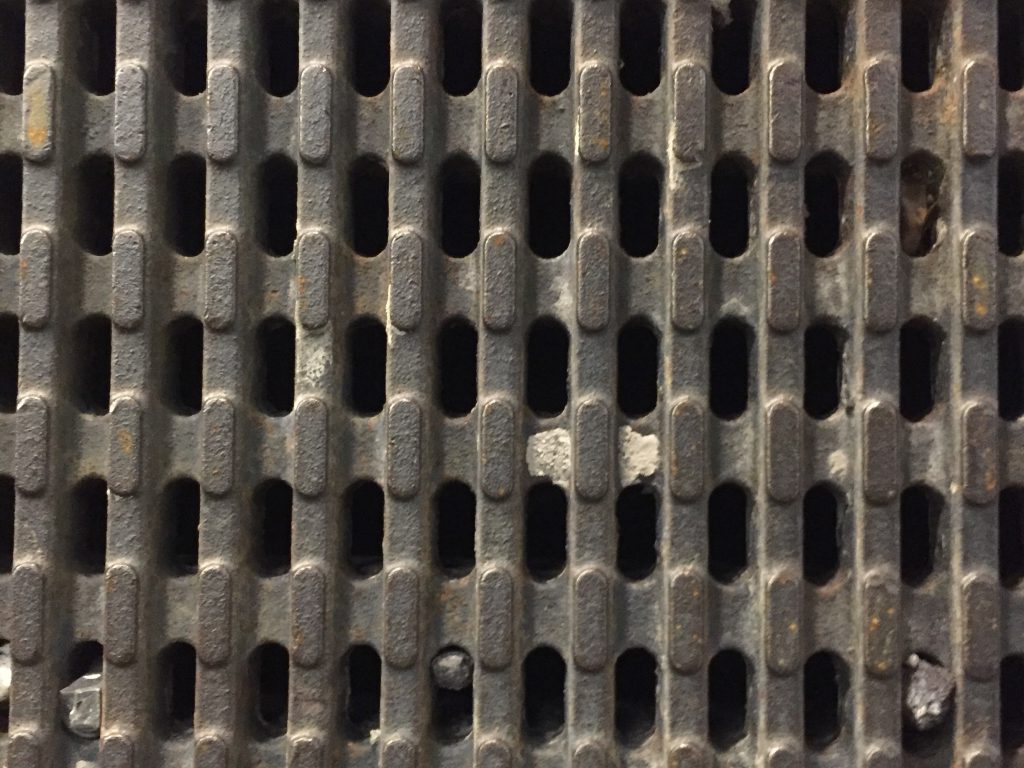 Dark rust brown iron grate with holes