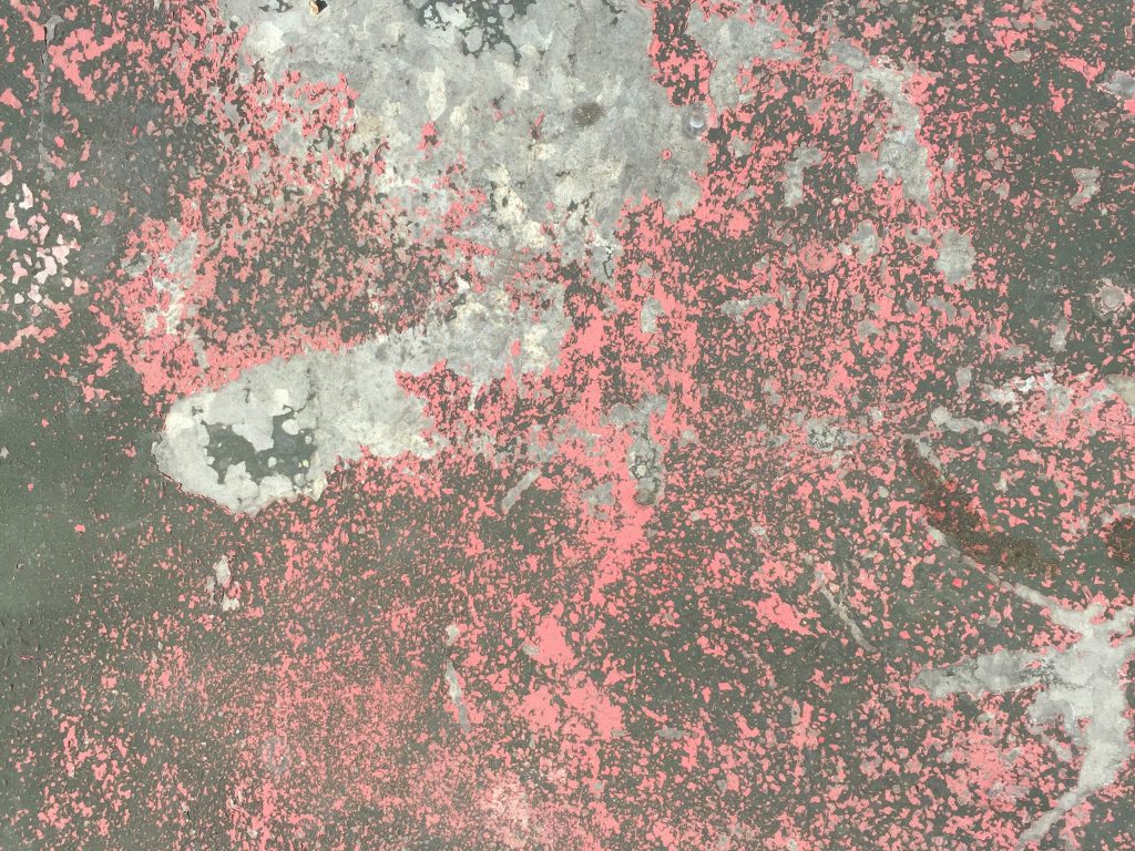 Red and black paint chipping away creating grungy surface