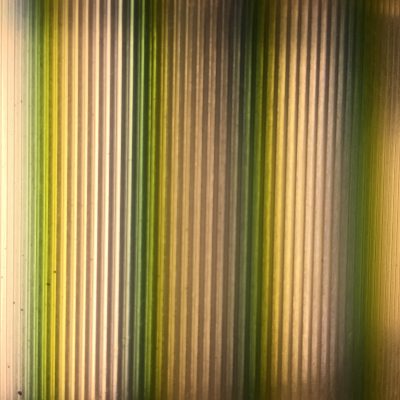 Vertical bars of light featuring light yellow mixed with dark green