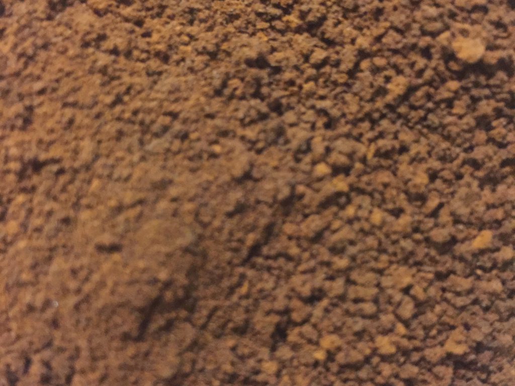 Dark brown coffee grounds close up