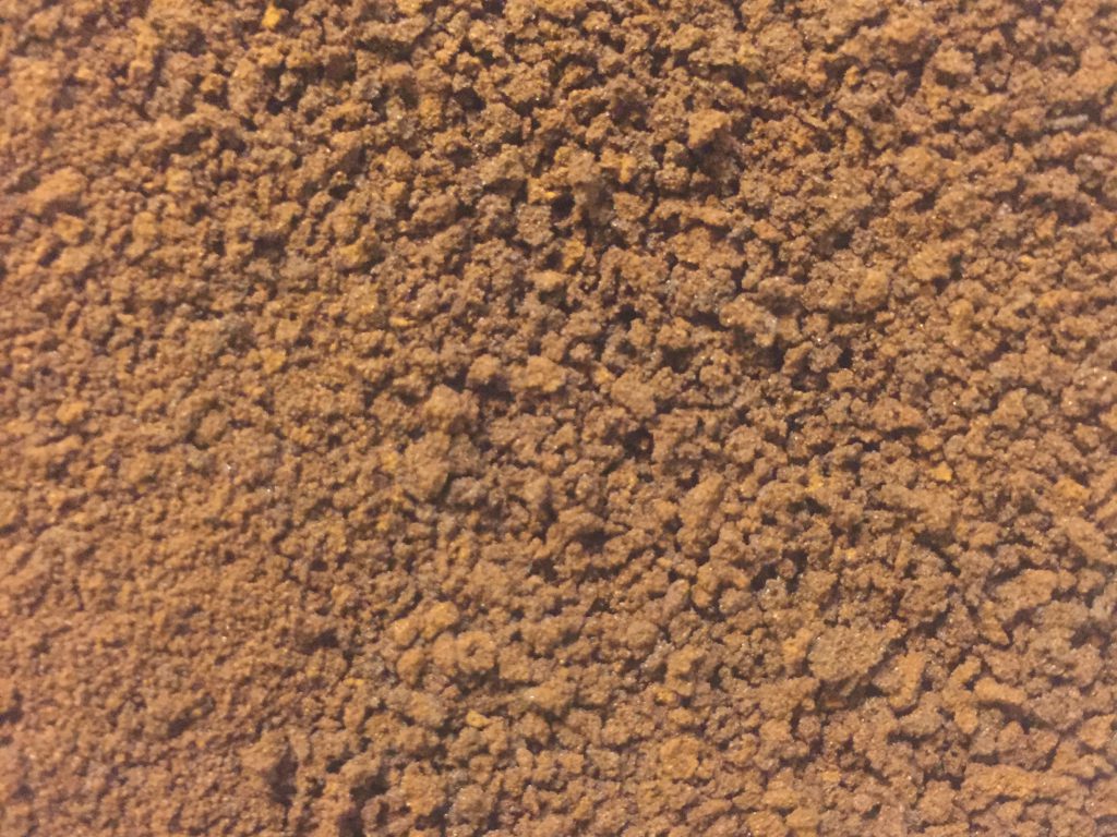 Light brown coffee grounds close up texture