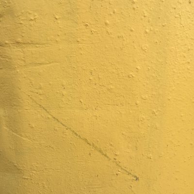 Bright yellow painted wall with lots of texture