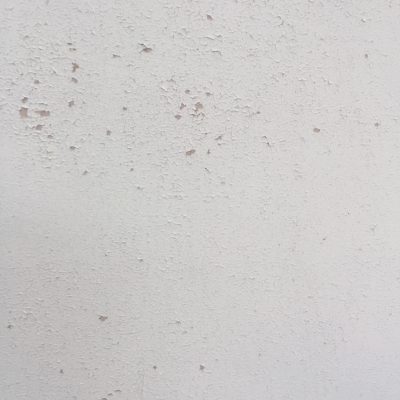 White chipped paint over concrete wall