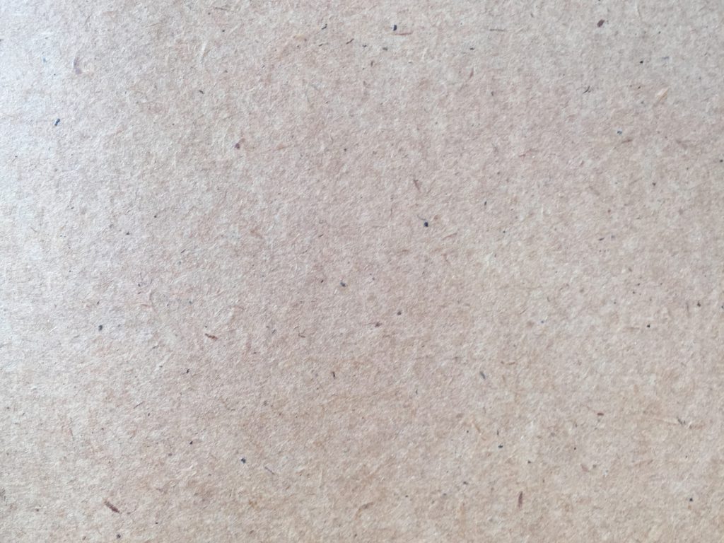 Speckled paper texture with lots of grain and hints of light pink