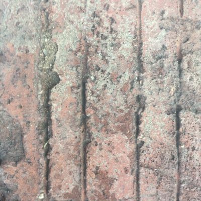 Close up of grungy red brick pavement