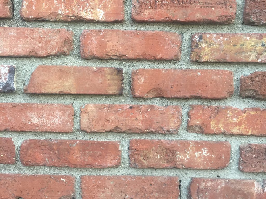 Brick wall pattern. Large gaps between bricks filled with concrete.