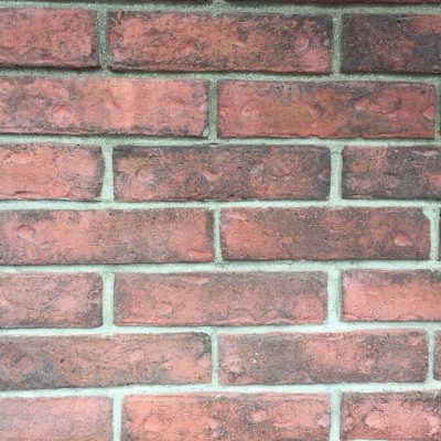 Red brick wall with dark smudges