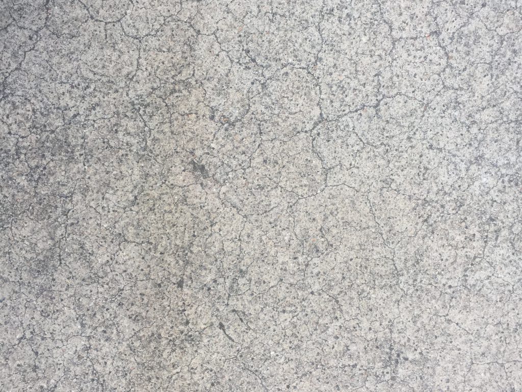 Textured concrete with fractal cracks running from top to bottom