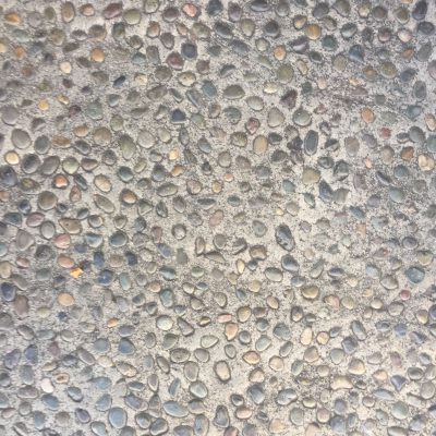 Concrete with embedded colorful pebbles on sidewalk slab