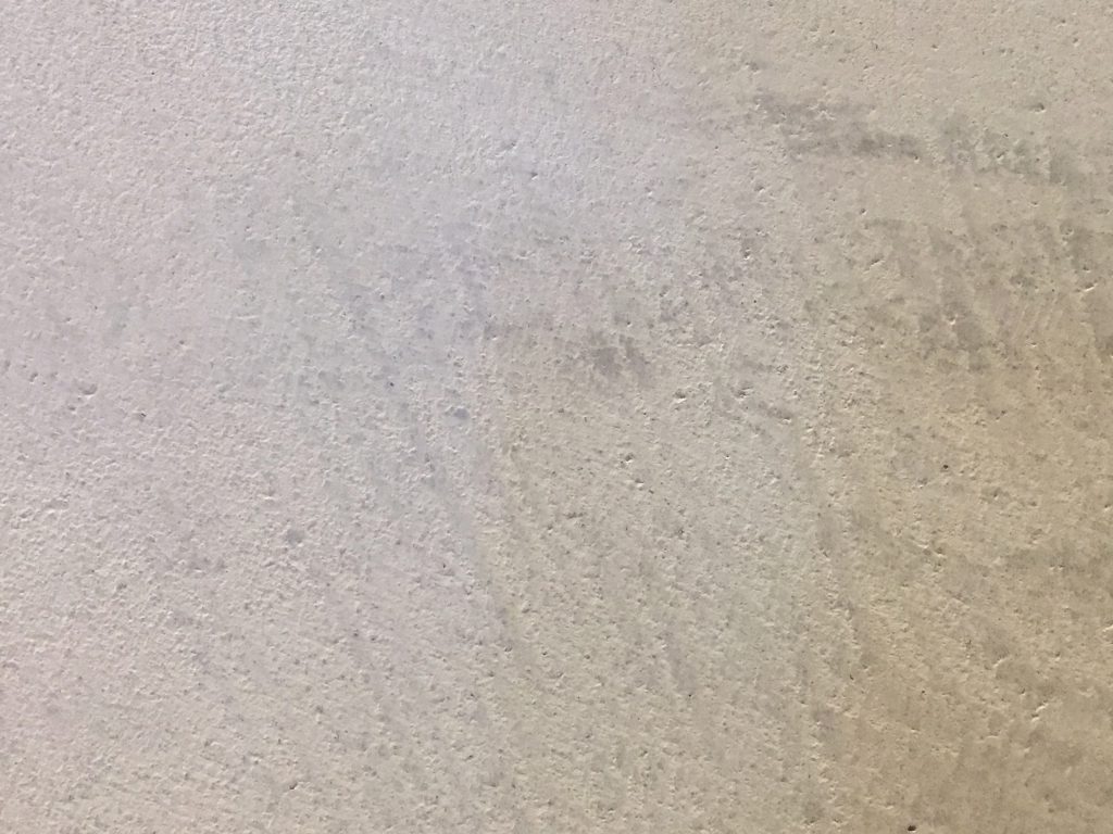 Beige concrete wall with light texture and brush marks