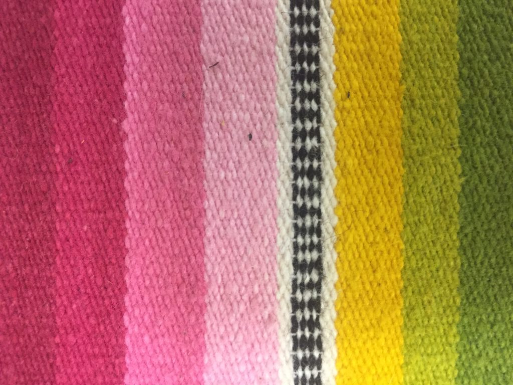 Colorful Mexican blanket with vertical bars of textured color