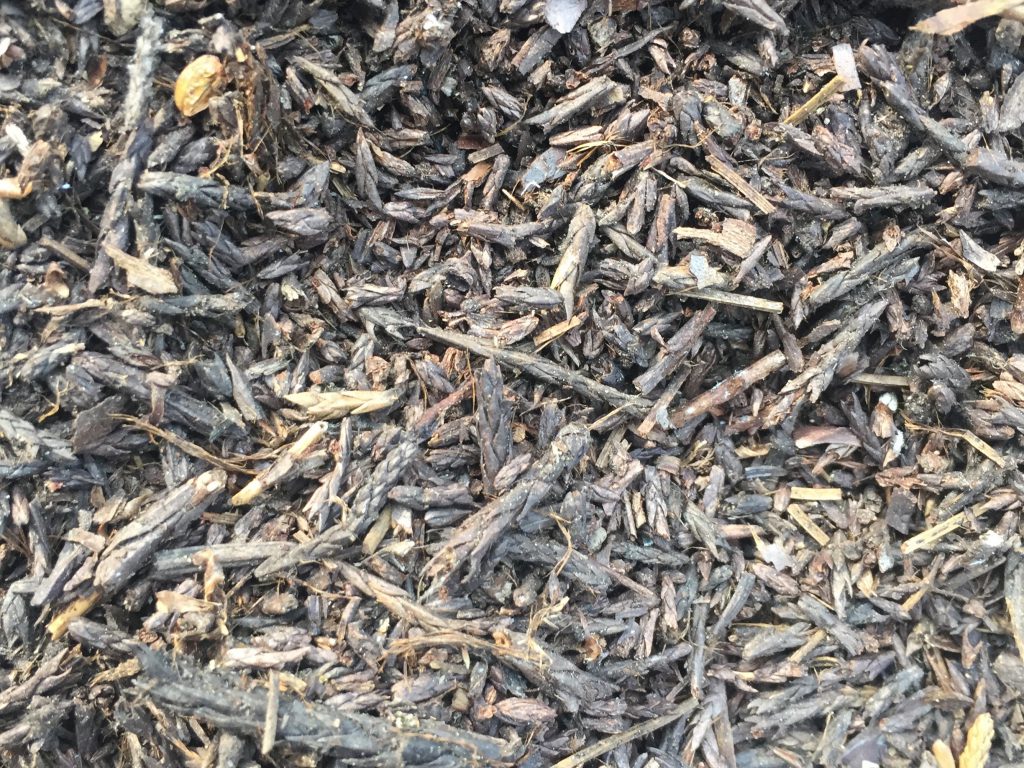 Bed of mulch with range of brown wood chunks