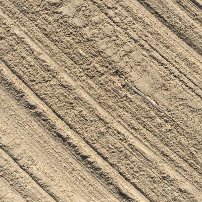 Smooth light brown sand with diagonal brush marks