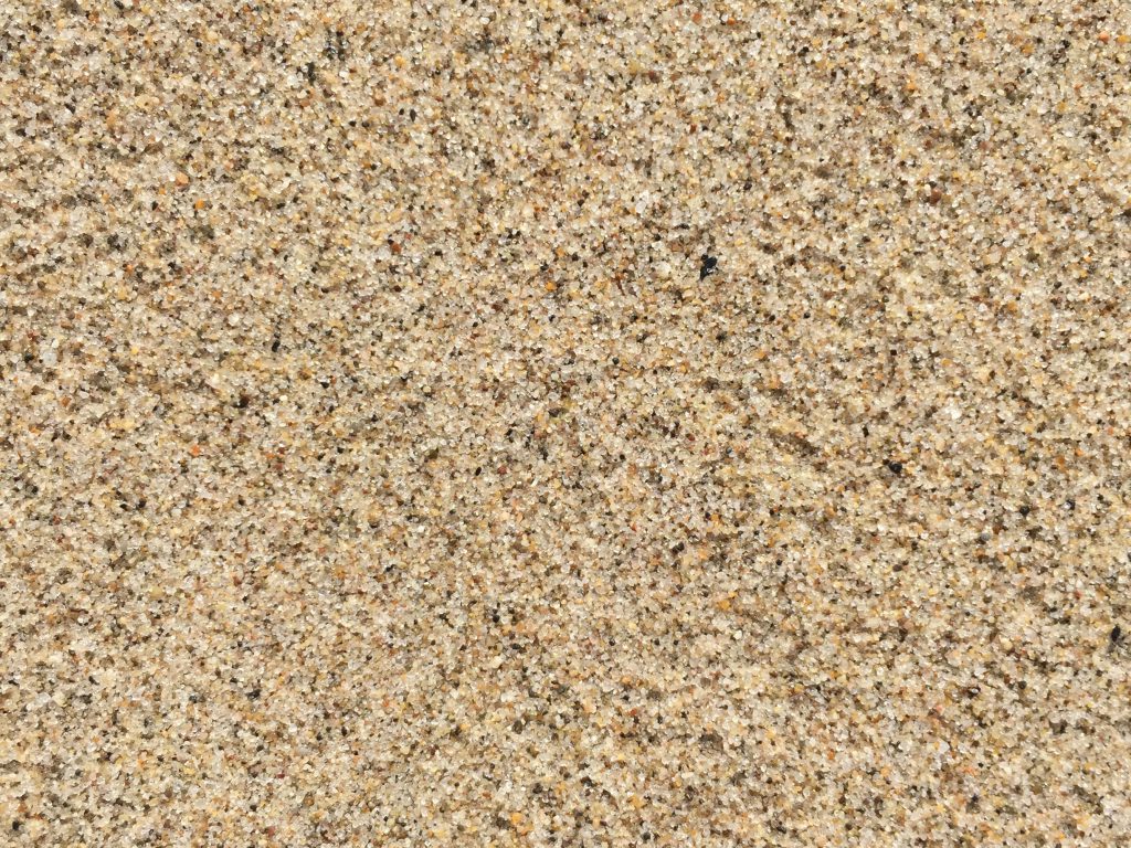 Noisy speckled wet beach sand texture
