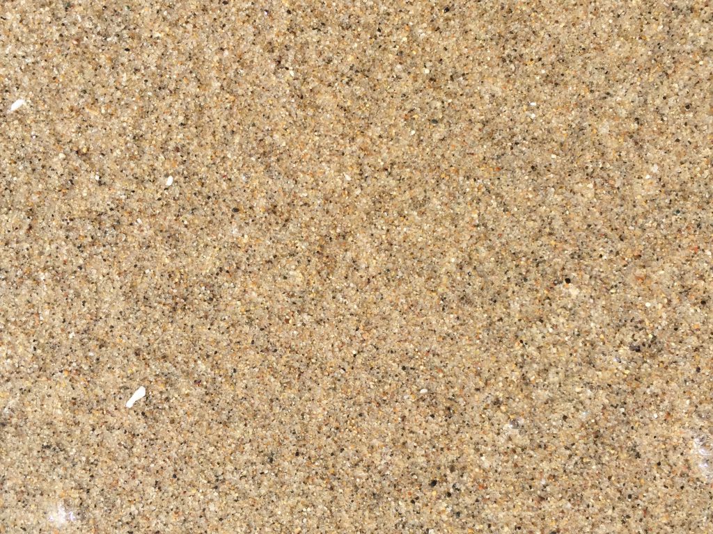 speckled glossy sand from wet beach texture