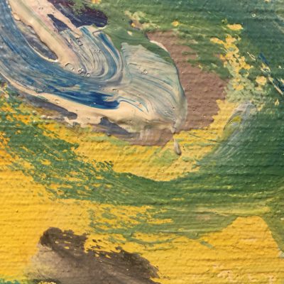 Close up of yellow paint on canvas with variety of brush strokes