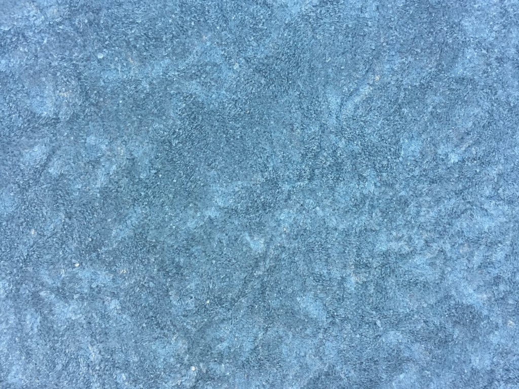 Flat blue surface area covered in frost crystals