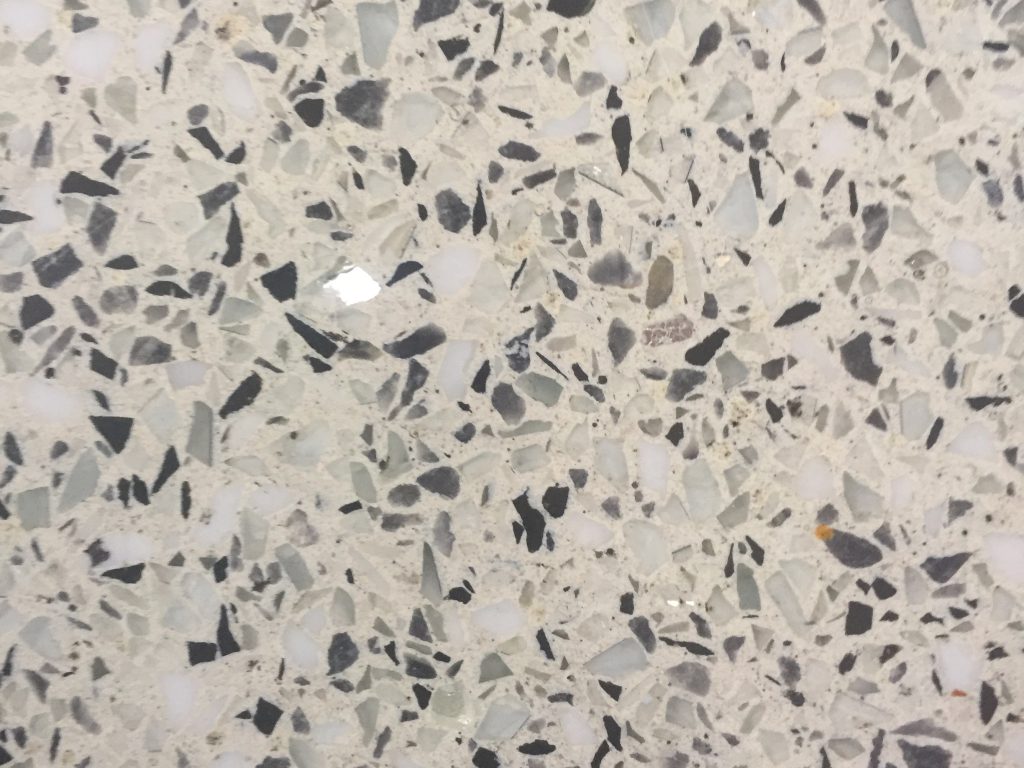 Off white floor with multicolored rocks embedded