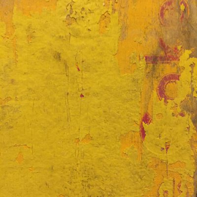 Layers of chipping yellow paint on wood crate