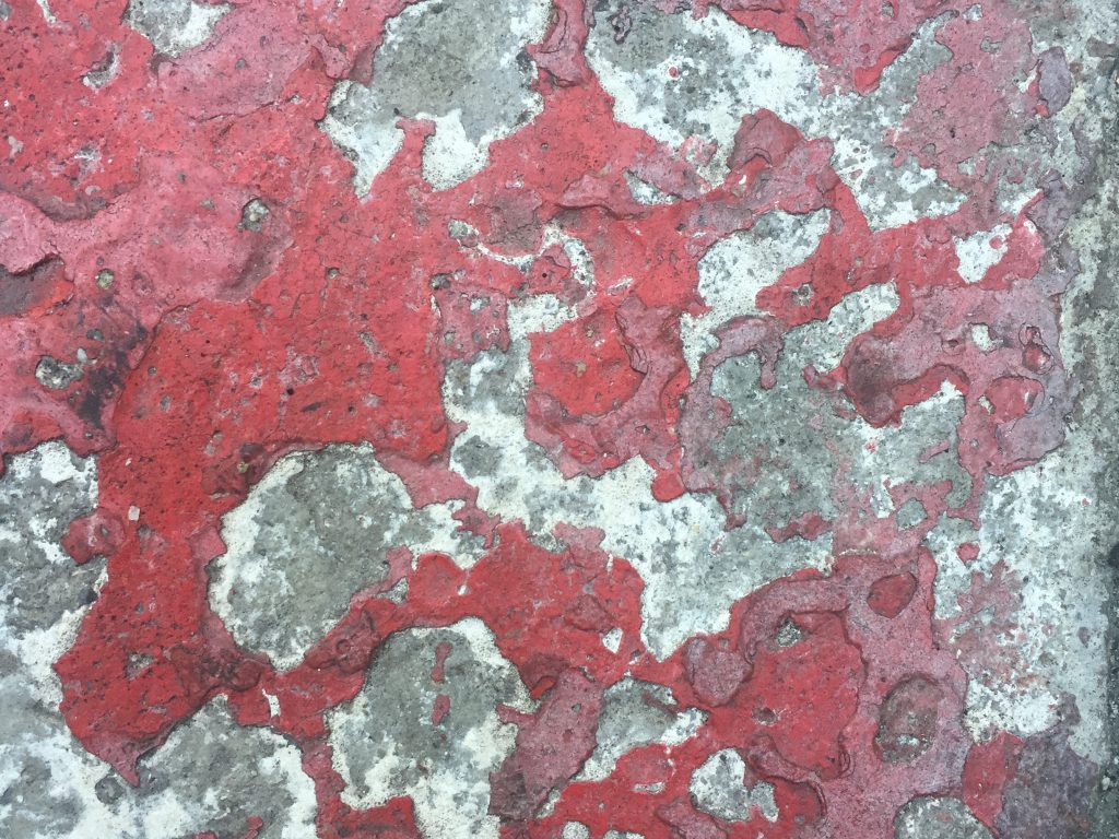 Beat up metal with red flaking paint