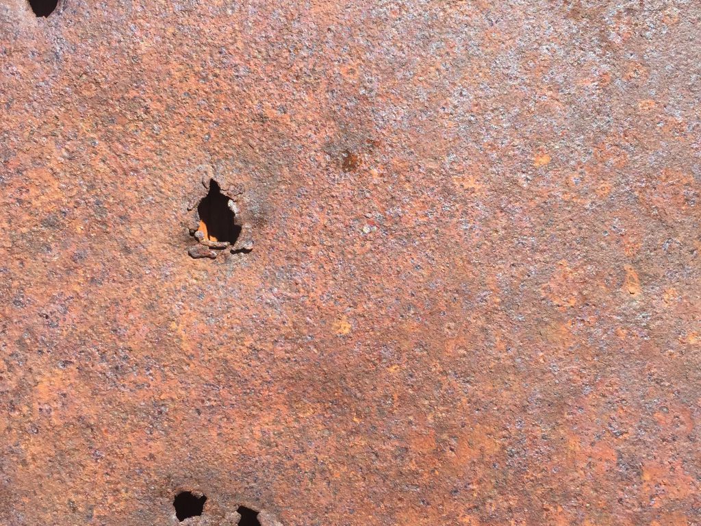 Rusty metal wall with holes