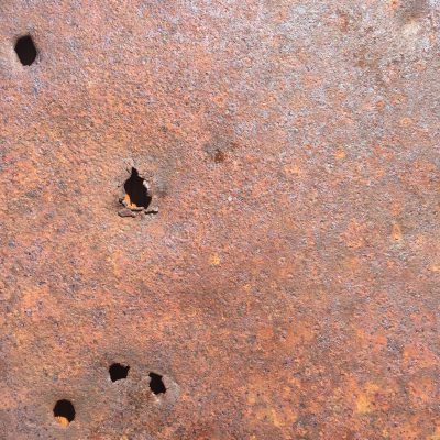 Rusty metal wall with holes