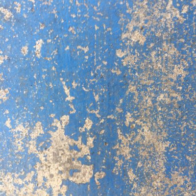 Light colored concrete with chipping blue paint