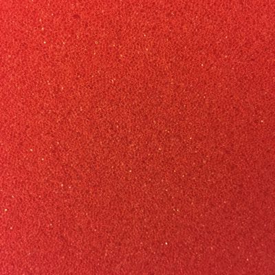 Red plastic texture close up with specs of dark, mid and specular highlights