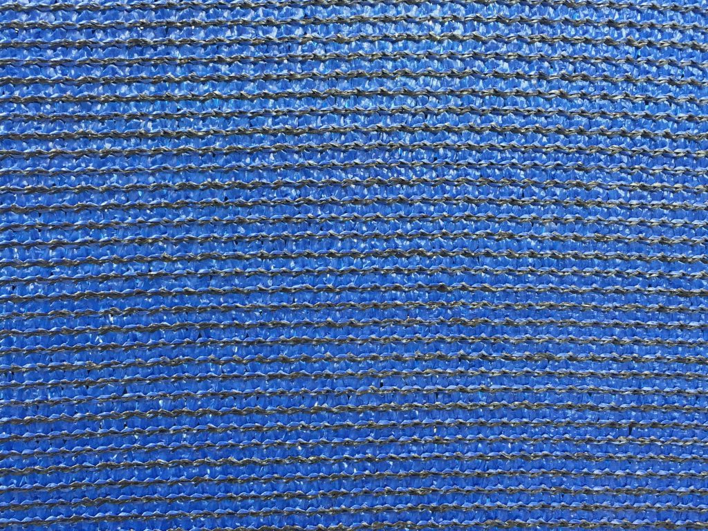 Detailed shot of black stitching on a shiny blue material