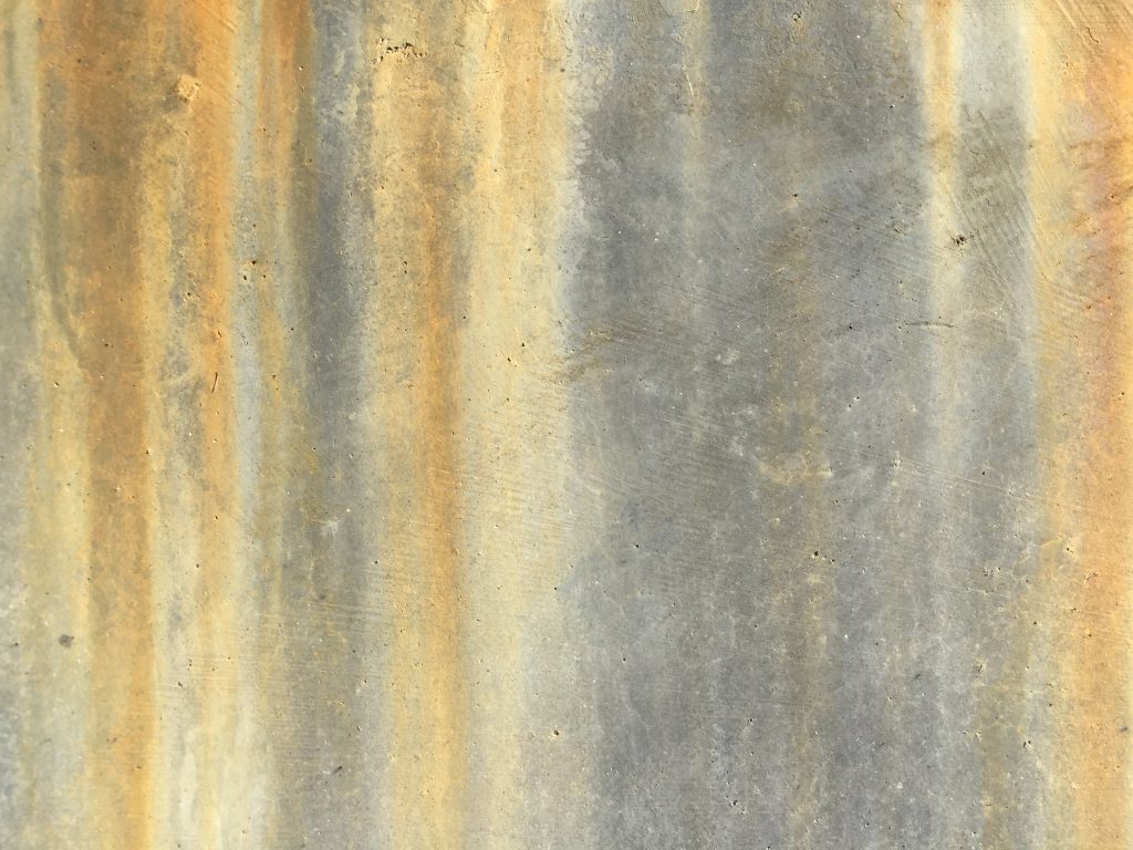 Light grey concrete wall with rust streaks