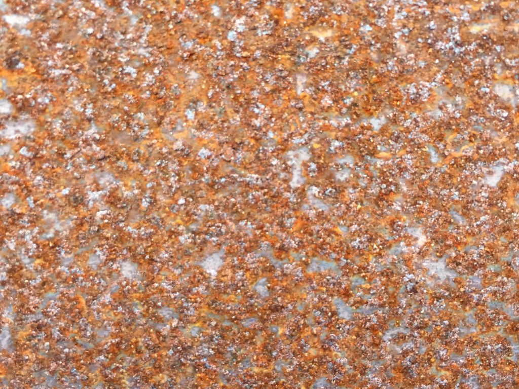 Rough metal texture full of bright brown rust and bits of silver metal shining through
