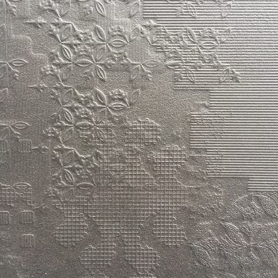 Dark silver wall paper with metallic like sheen featuring embossed designs with lines, grids and floral patterns