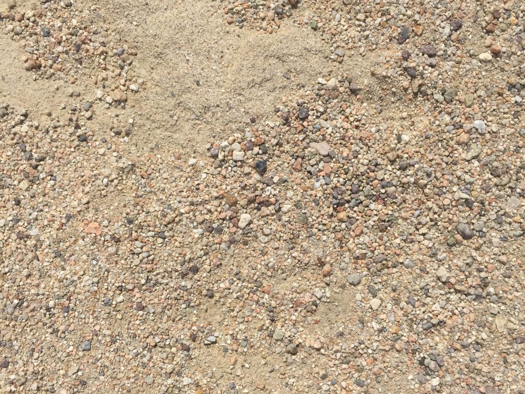 Light brown dirt with small pebbles featuring various shapes and colors