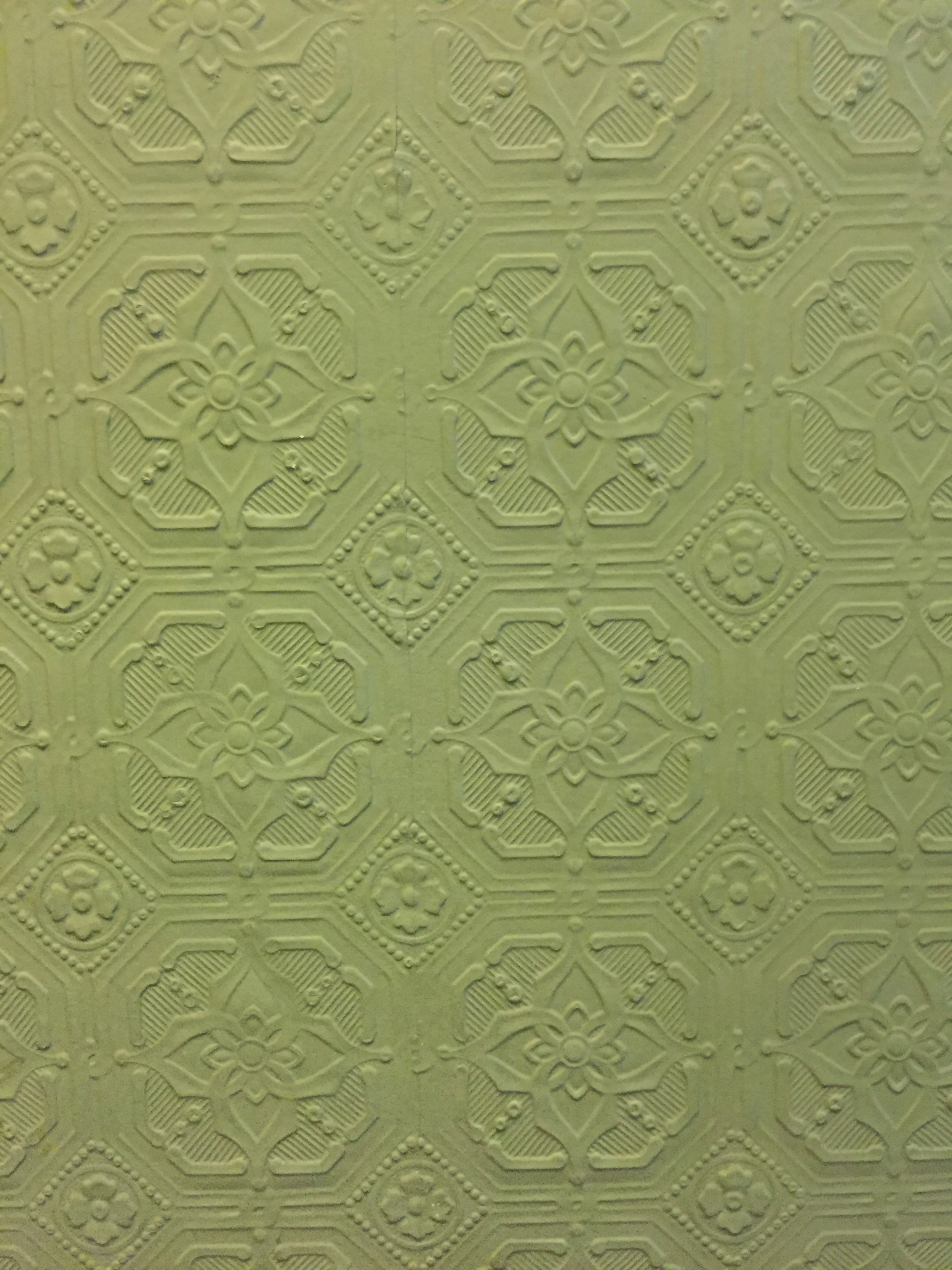 Green wall paper with ornate patterns