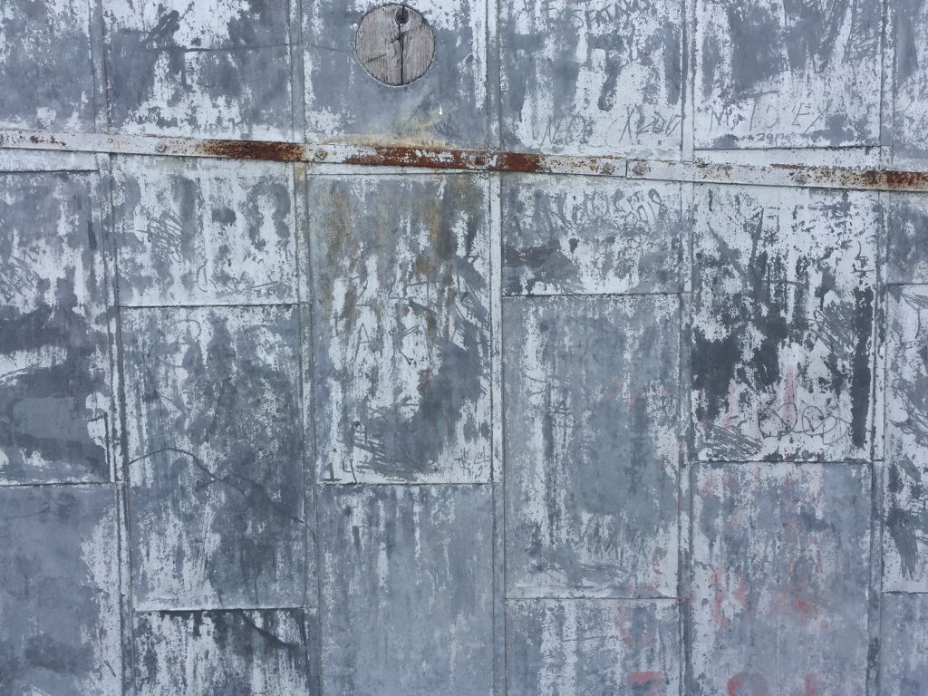 Grey/blue scuffed up metal wall