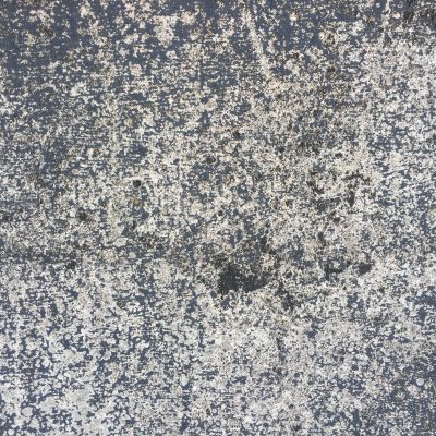 Cracked concrete with sparse black scuffs