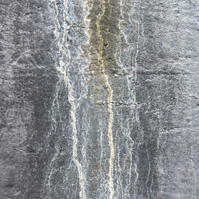 Charcoal grey stone wall with white drips