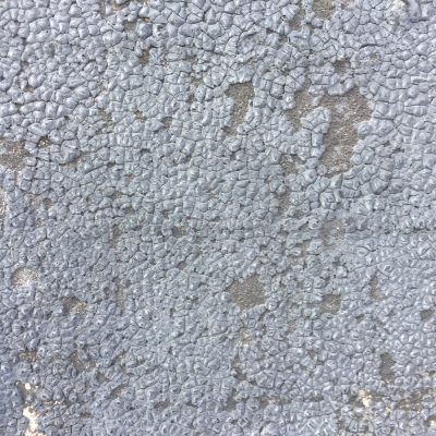 Medium grey cracking tar on concrete wall