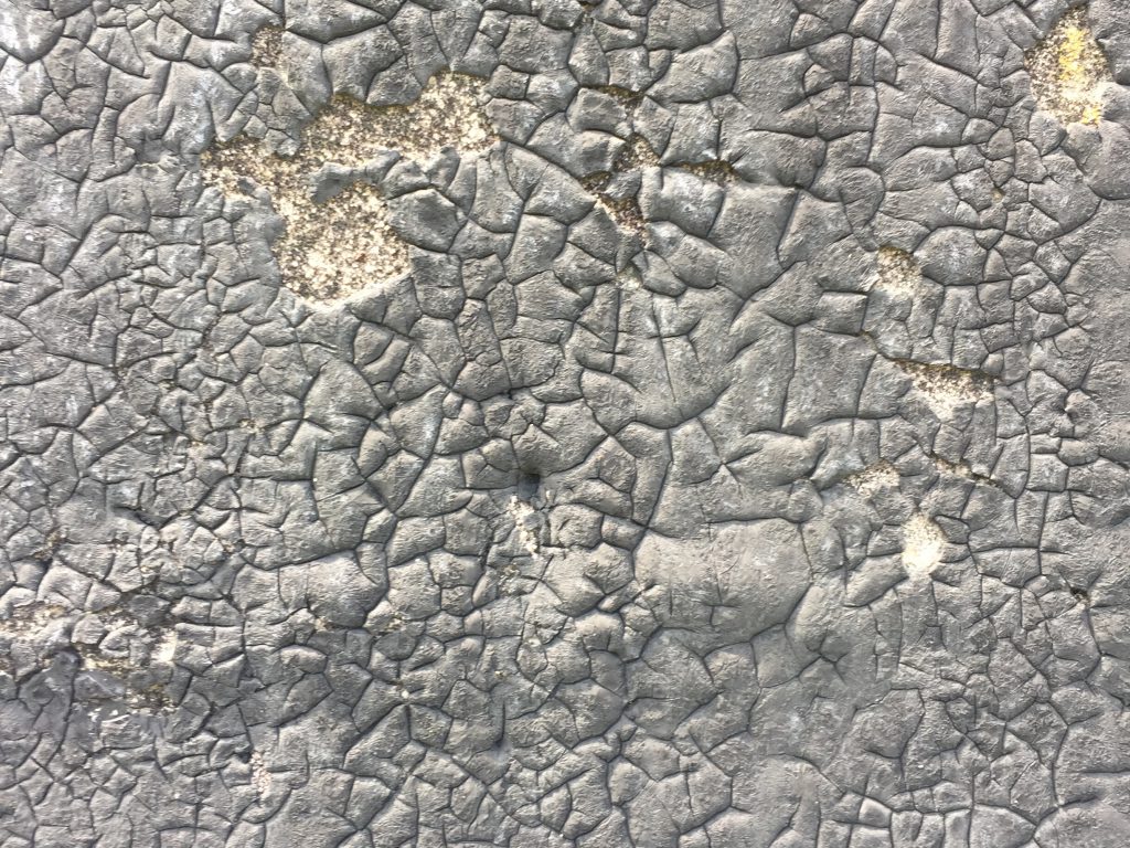 Cracking faded black tar close up