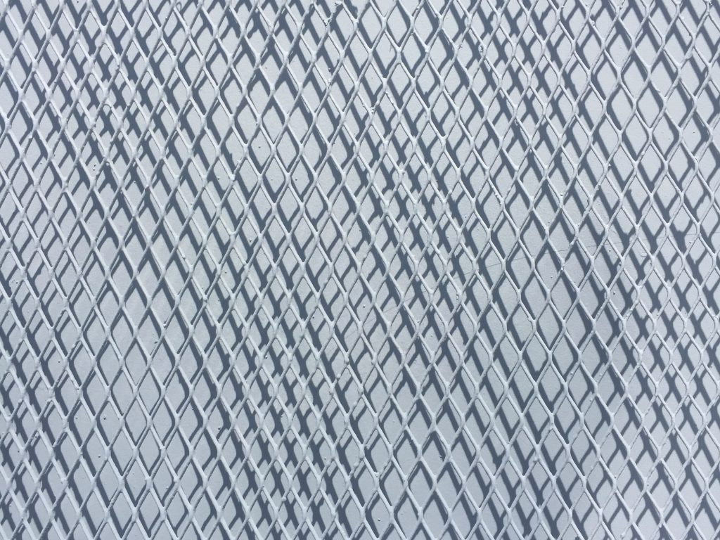 Metal fence over white wall