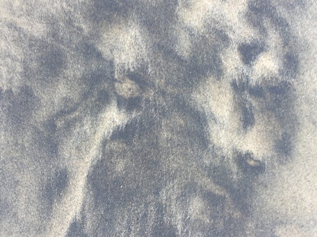 Black blotchy sand over tan base