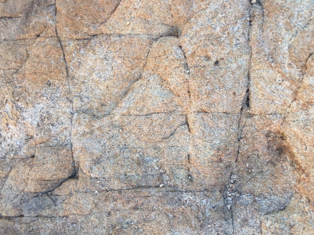 Rock surface with warm red color and breaks in surface
