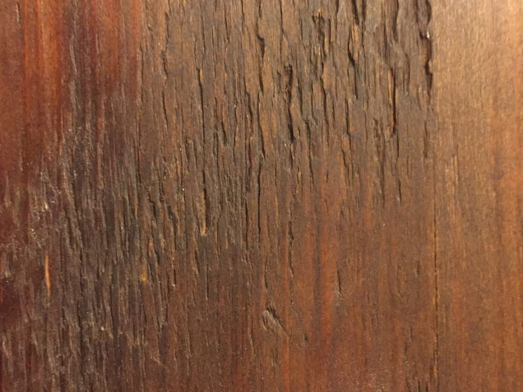 Dark brown stain on rough wood