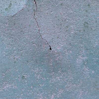 Turquoise color over corroded and cracked wall