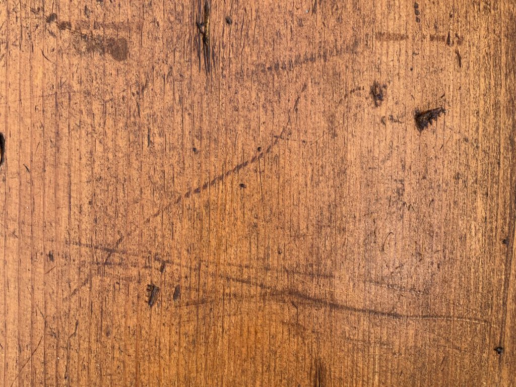 Top of a beat up old piece of wood furniture