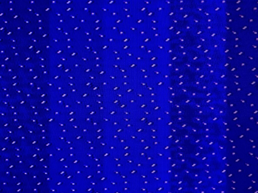 Hundreds of white dots in pattern over blue