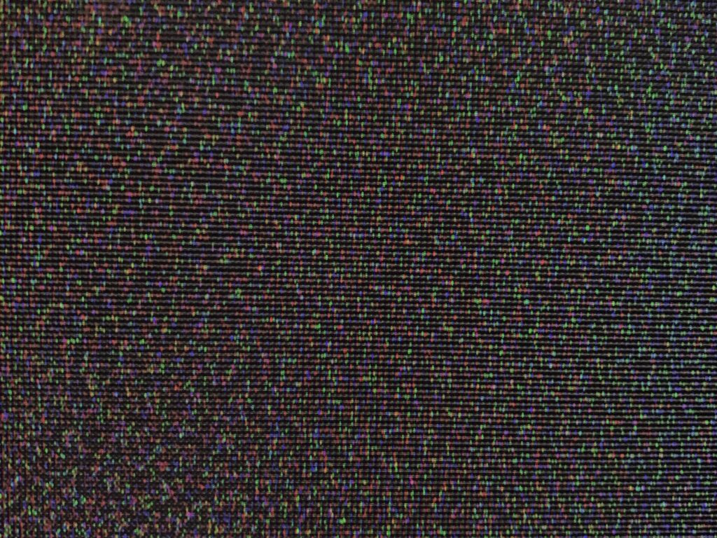 Purple, green and blue pixels spread over tv screen