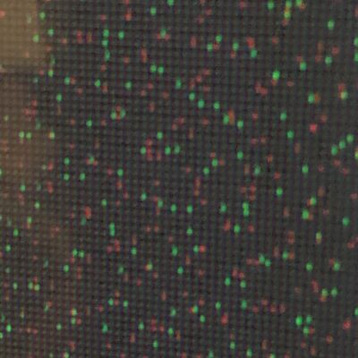 Blurry pixel close up of tv screen featuring red and green dots on black