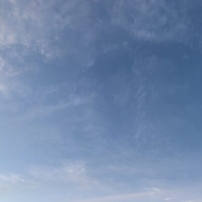 Light layer of clouds over gradient of blue sky