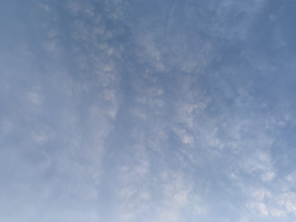 Fluffy white sparse clouds in gradient blue sky